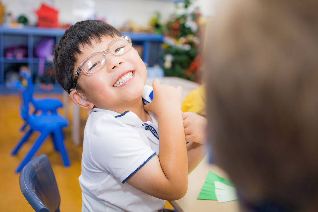 A happy child playing with coloured paper.