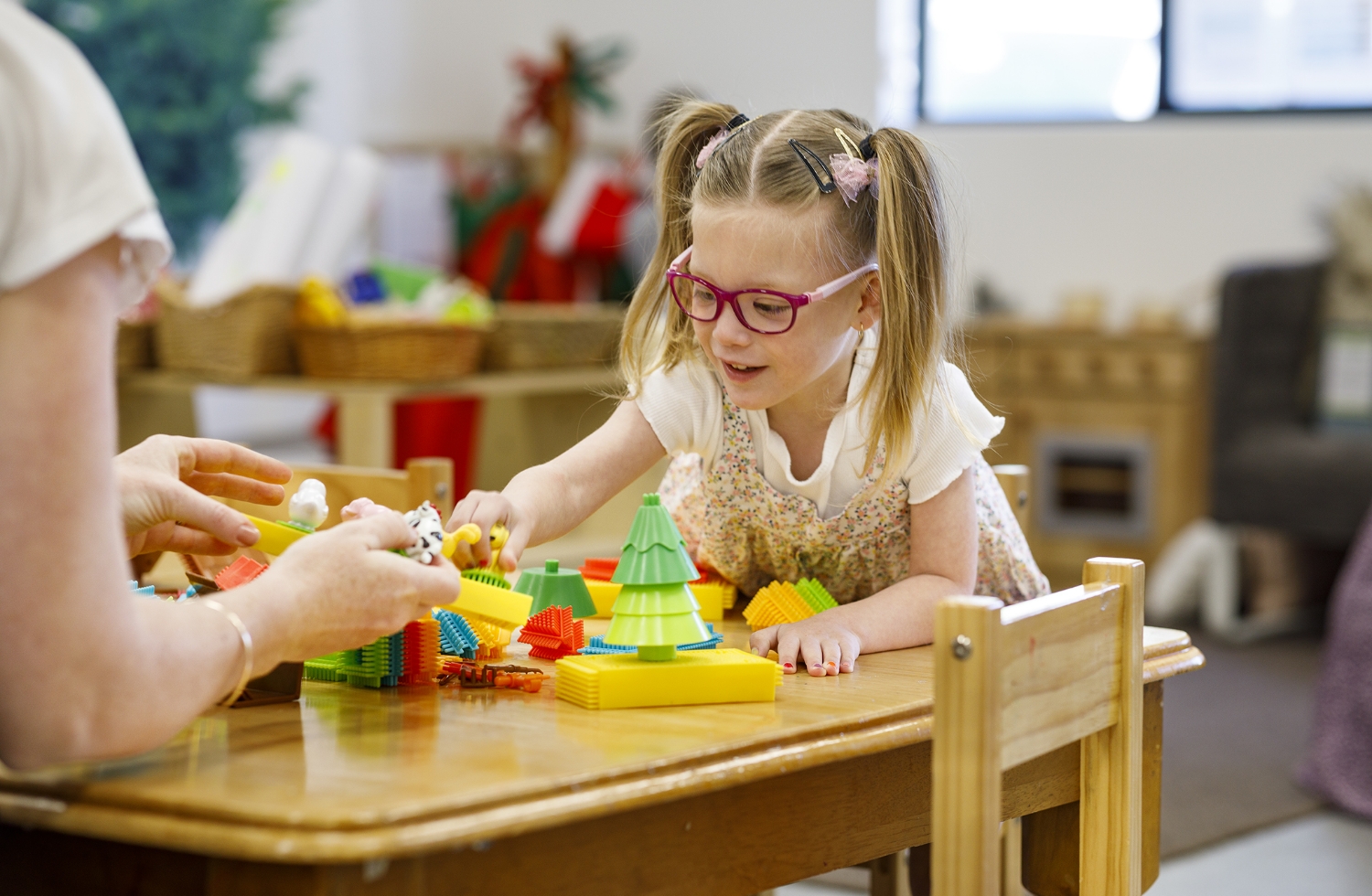 A child playing with coloured blocks and animals.