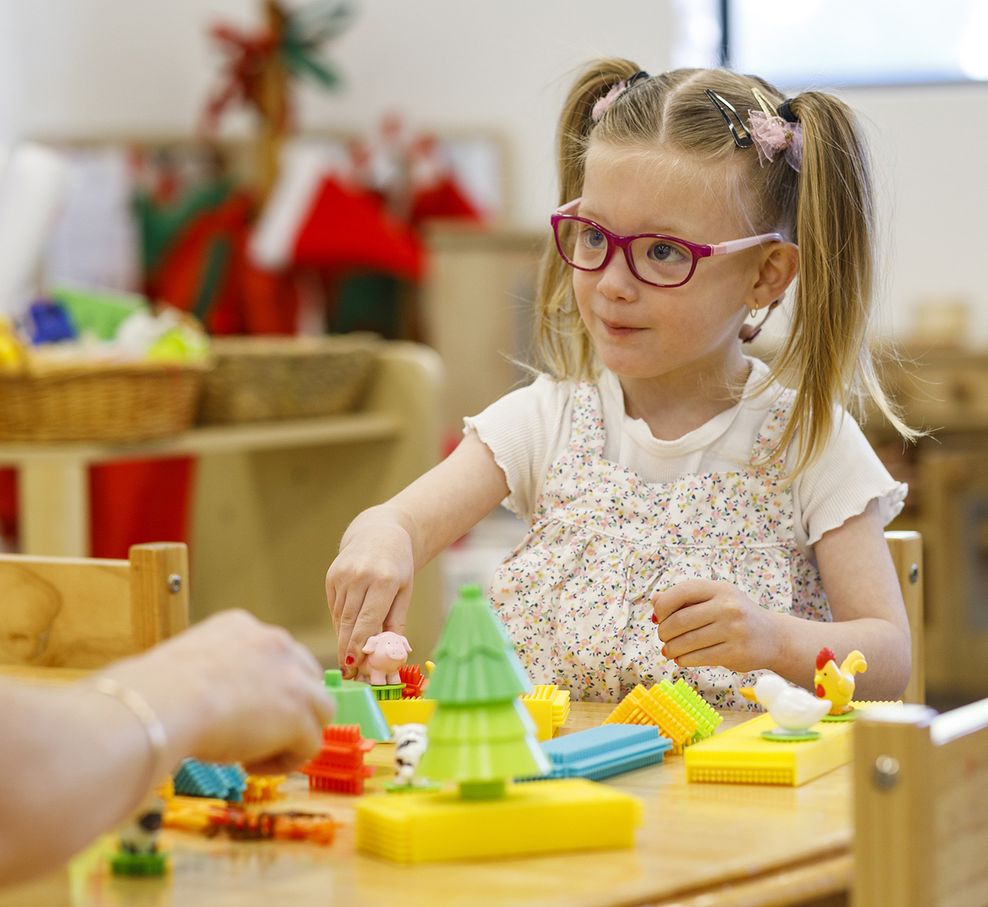 A child playing with toy animals and blocks.