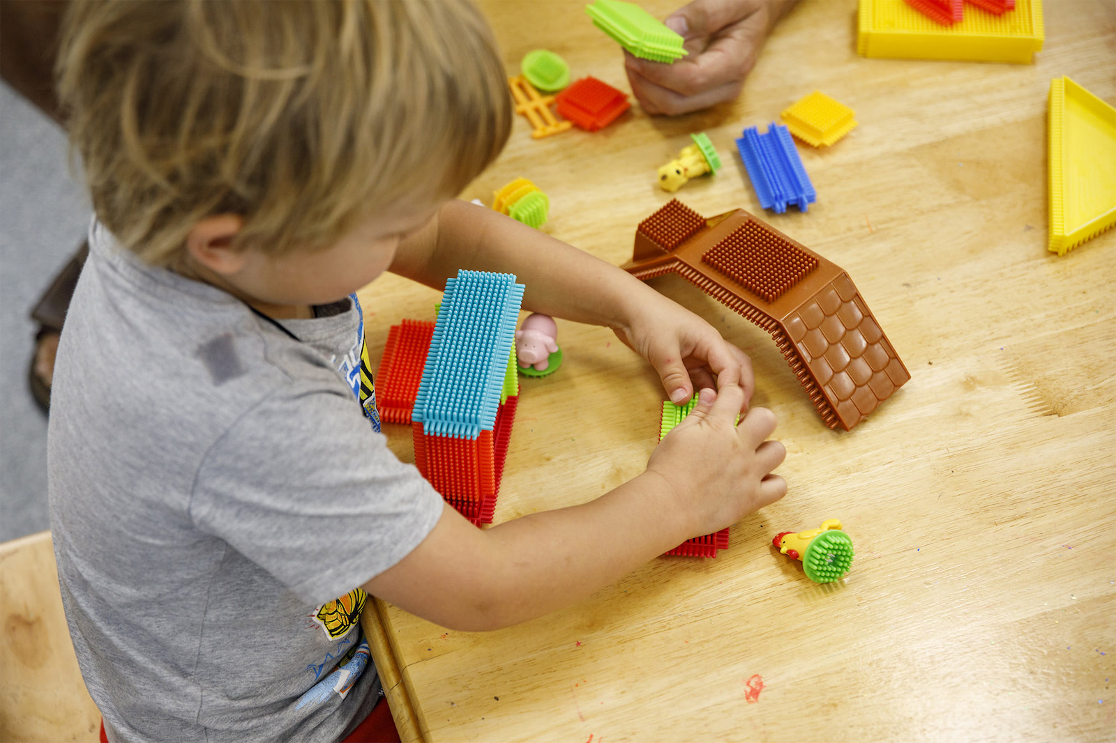 A child connecting coloured toy blocks