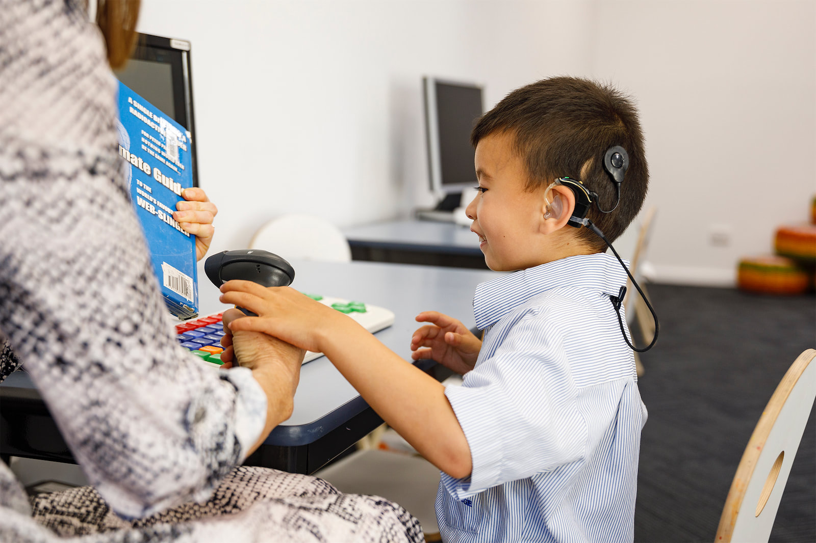 A child with cochlear implants scanning a barcode.