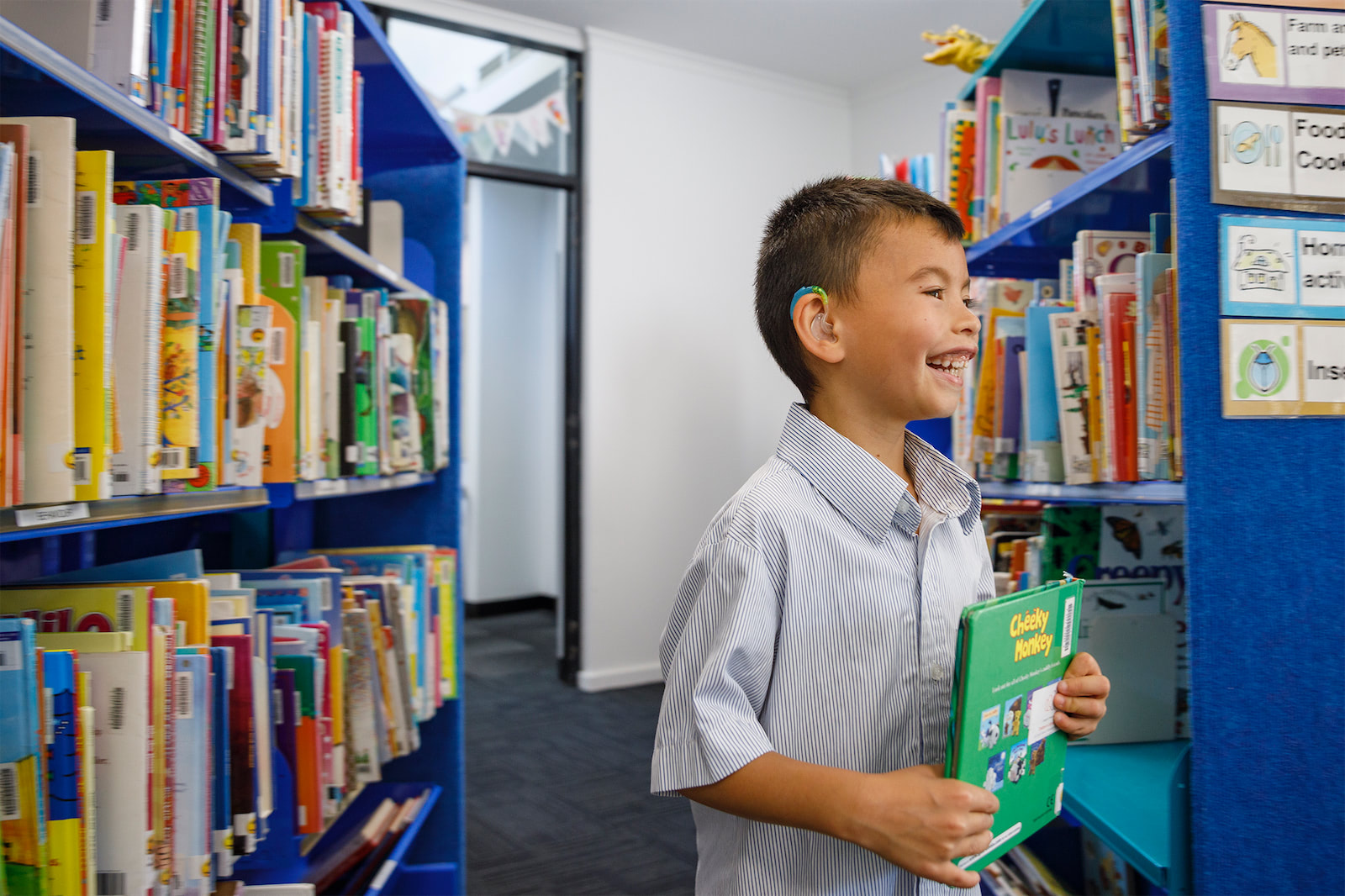 An excited child getting a picture book from the library.