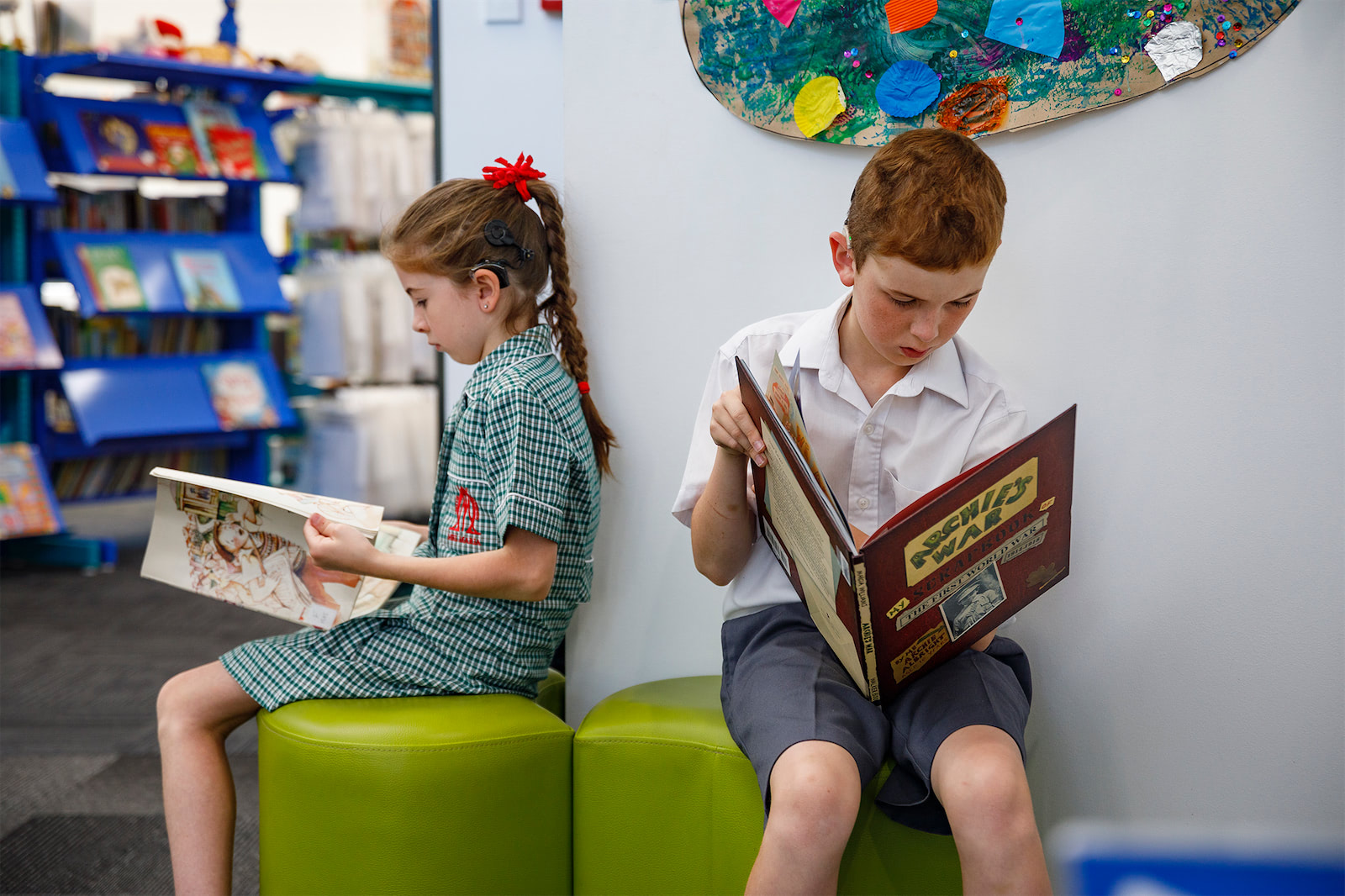 Children with hearing loss reading books.