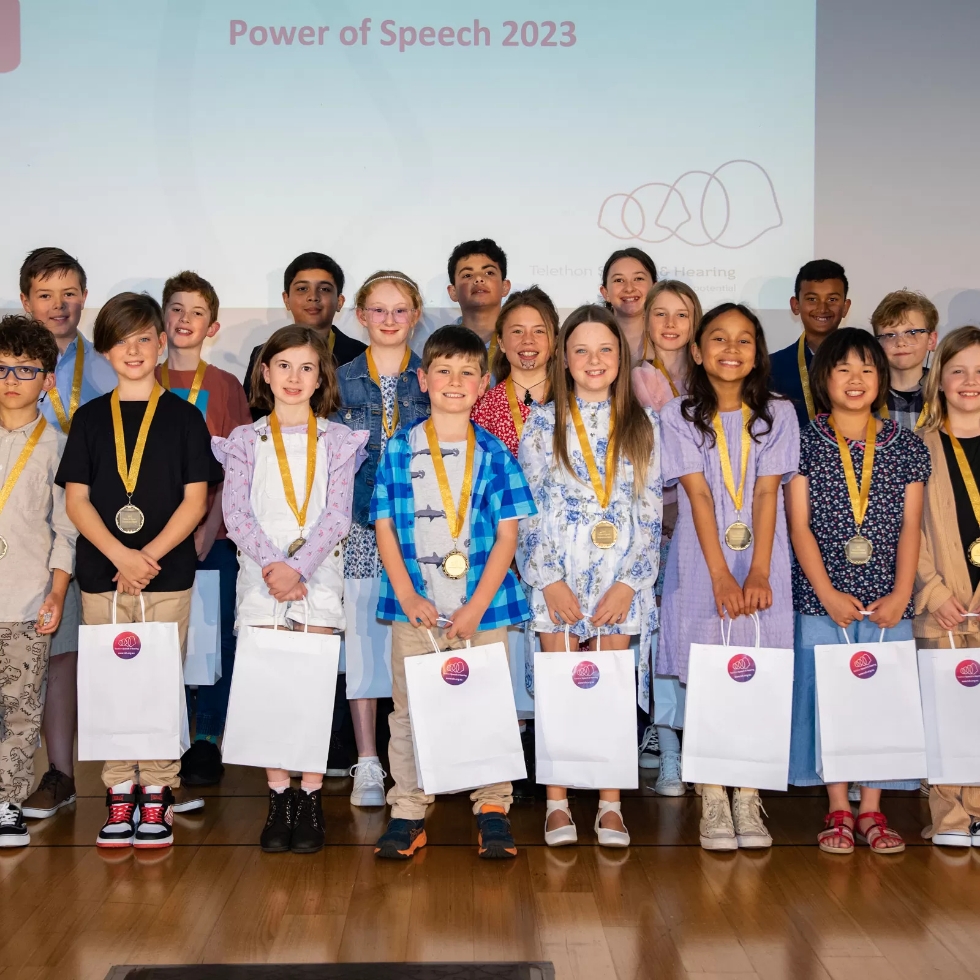 Smiling children holding their awards at the TSH Power of Speech Event in 2023.