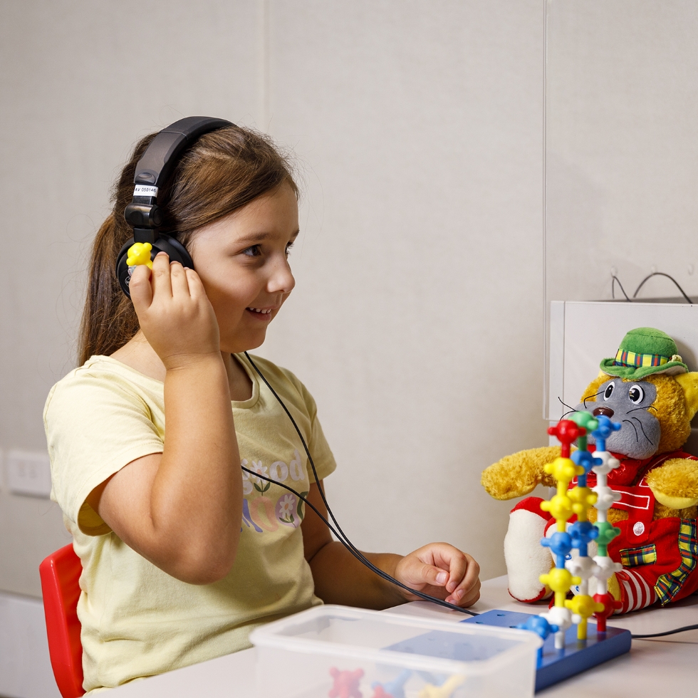 A child with headphones on playing with toys.