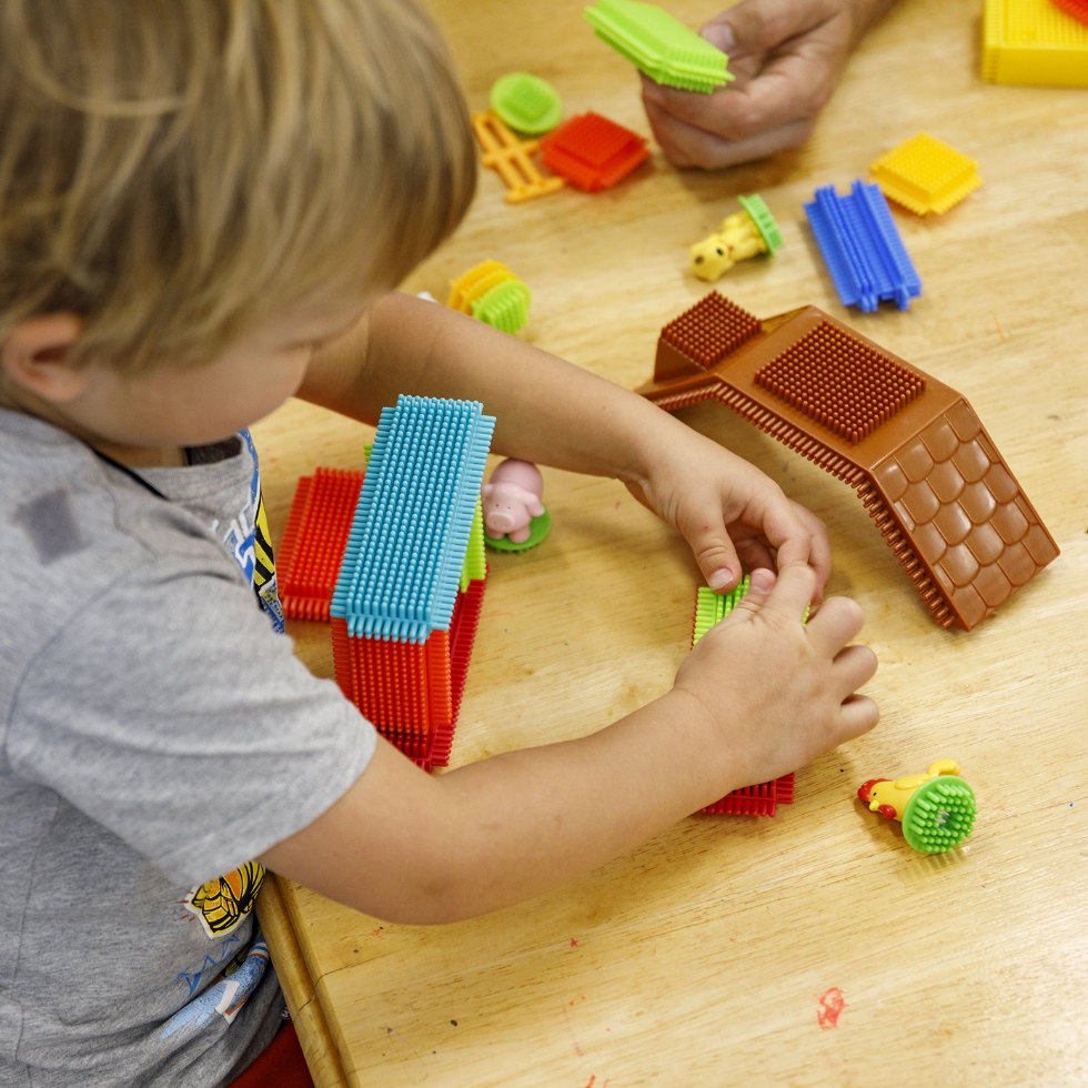 A child playing with coloured blocks.